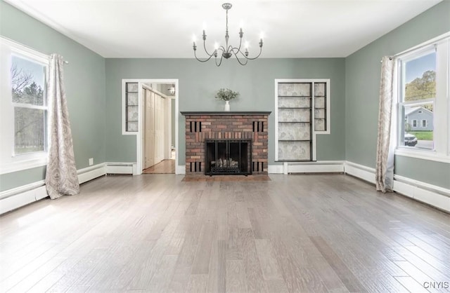 83 Salisbury St, Sandy Creek, NY 13083 - unfurnished living room with plenty of natural light, wood finished floors, a fireplace, and a notable chandelier