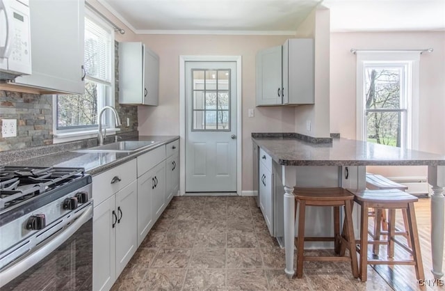 83 Salisbury St, Sandy Creek, NY 13083 - kitchen featuring plenty of natural light, a breakfast bar, stainless steel gas stove, a sink, and white microwave
