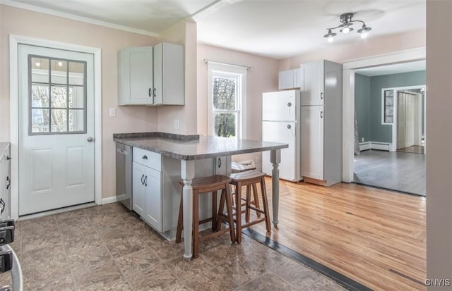 83 Salisbury St, Sandy Creek, NY 13083 - kitchen featuring freestanding refrigerator, a breakfast bar area, baseboards, a peninsula, and dark countertops