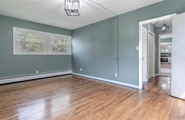 83 Salisbury St, Sandy Creek, NY 13083 - spare room with baseboards, a baseboard radiator, a chandelier, and wood finished floors