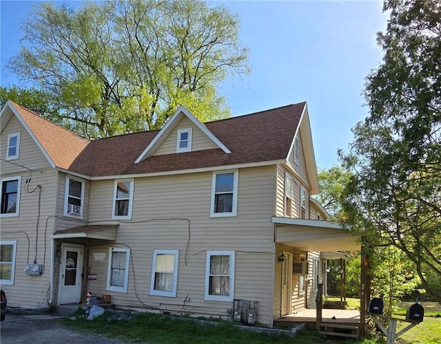 view of front facade with roof with shingles and covered porch