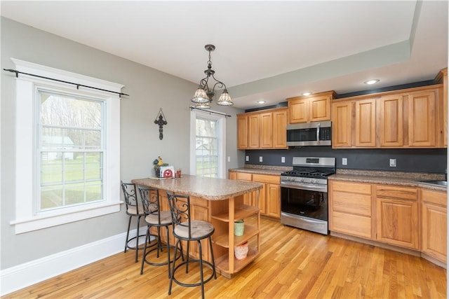 kitchen featuring a peninsula, recessed lighting, light wood-style flooring, baseboards, and appliances with stainless steel finishes