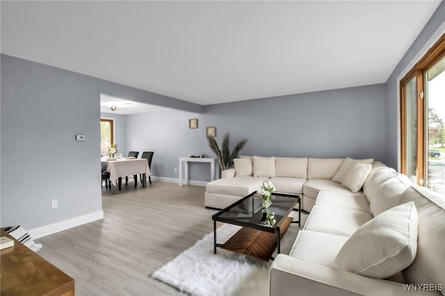 living area with baseboards and wood finished floors