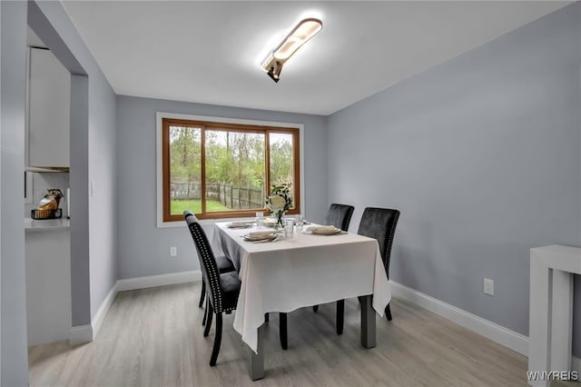 dining area with light wood-style flooring and baseboards
