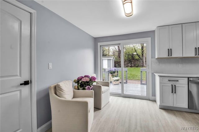 doorway with light wood finished floors and baseboards
