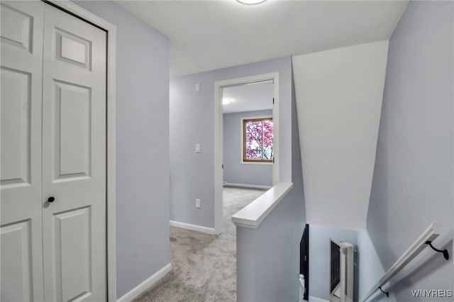 corridor with baseboards, an upstairs landing, and carpet
