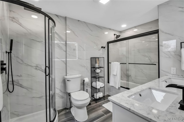 bathroom featuring tile walls, a marble finish shower, and a sink