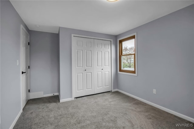 unfurnished bedroom featuring carpet, baseboards, and a closet