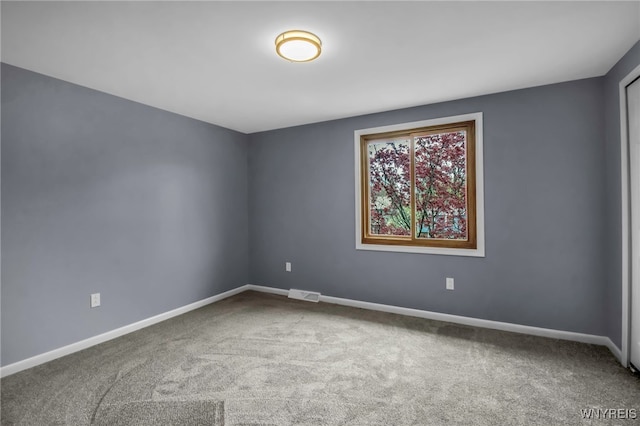 carpeted empty room featuring visible vents and baseboards