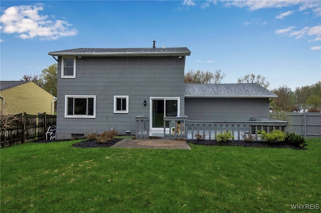 rear view of property featuring a lawn and a fenced backyard