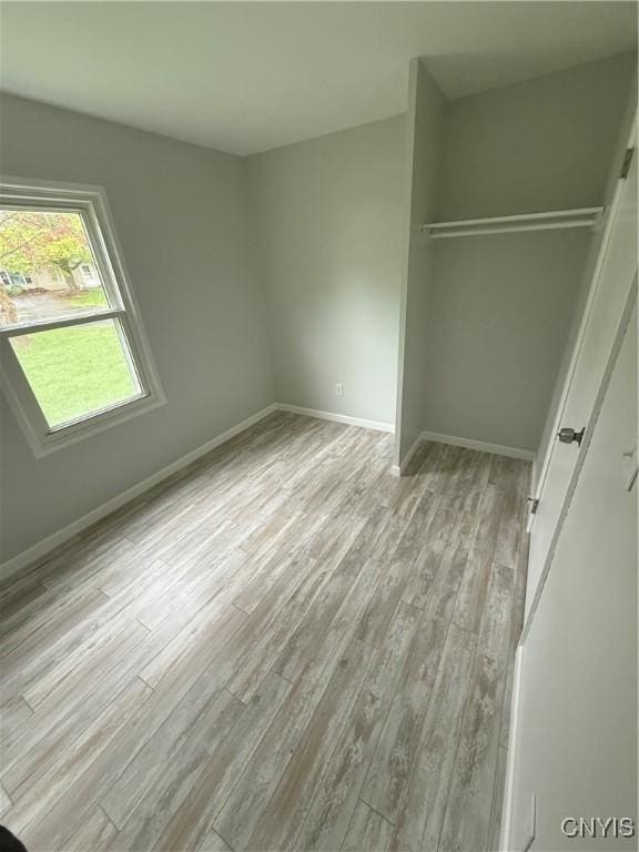 unfurnished bedroom with baseboards, a closet, and wood finished floors