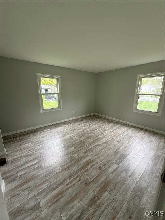 spare room featuring wood finished floors and baseboards
