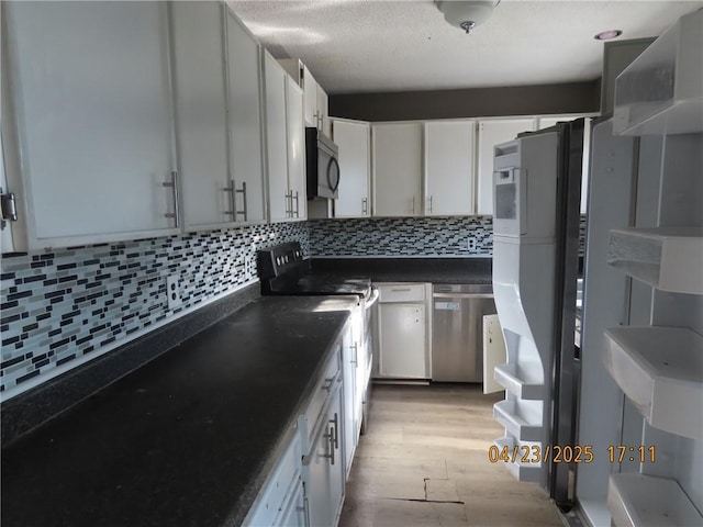 6937 State Highway 56, Potsdam, NY 13676 - kitchen featuring appliances with stainless steel finishes, white cabinets, dark countertops, tasteful backsplash, and light wood-type flooring
