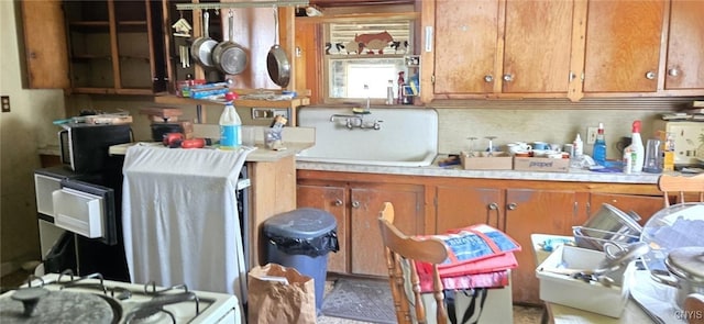107 Mill St, Elbridge, NY 13060 - kitchen with brown cabinetry, light countertops, decorative backsplash, and a sink