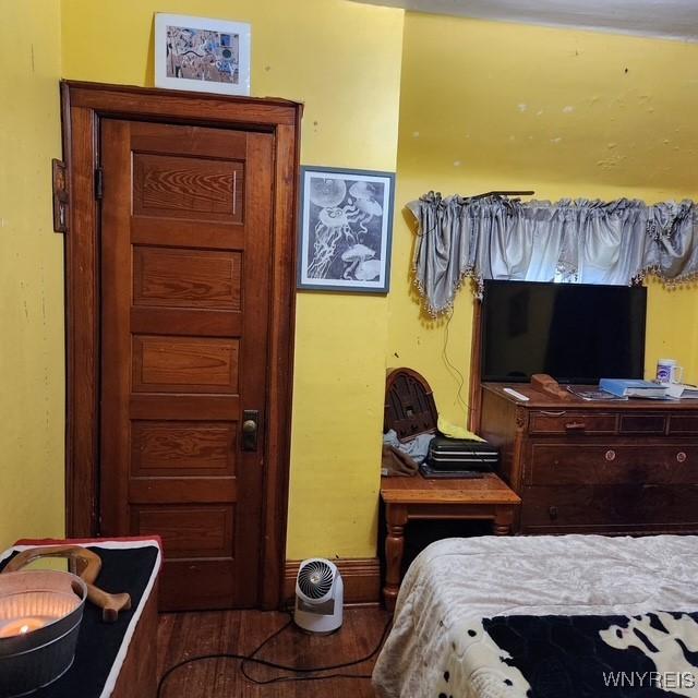 bedroom with baseboards and wood finished floors