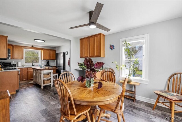 dining room with dark wood-style flooring, baseboards, and ceiling fan