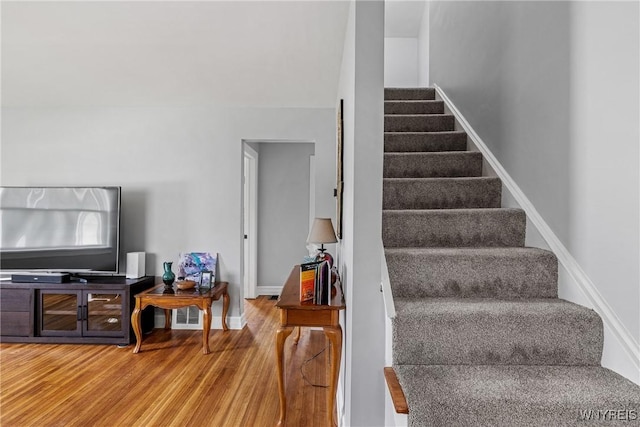 staircase with wood finished floors and baseboards