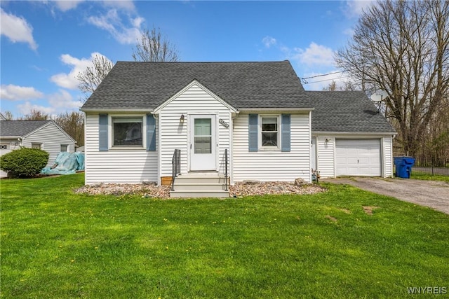 cape cod-style house featuring a shingled roof, an attached garage, a front yard, and aphalt driveway