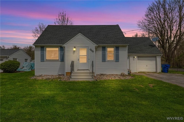cape cod-style house with an attached garage, a shingled roof, driveway, and a front yard