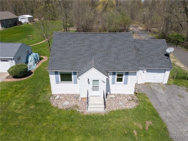 view of front of house featuring a front yard, roof with shingles, a garage, and aphalt driveway