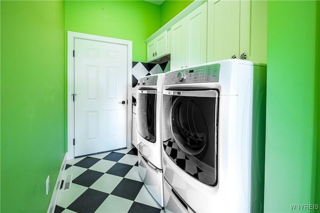 laundry area featuring cabinet space, dark floors, and washing machine and dryer