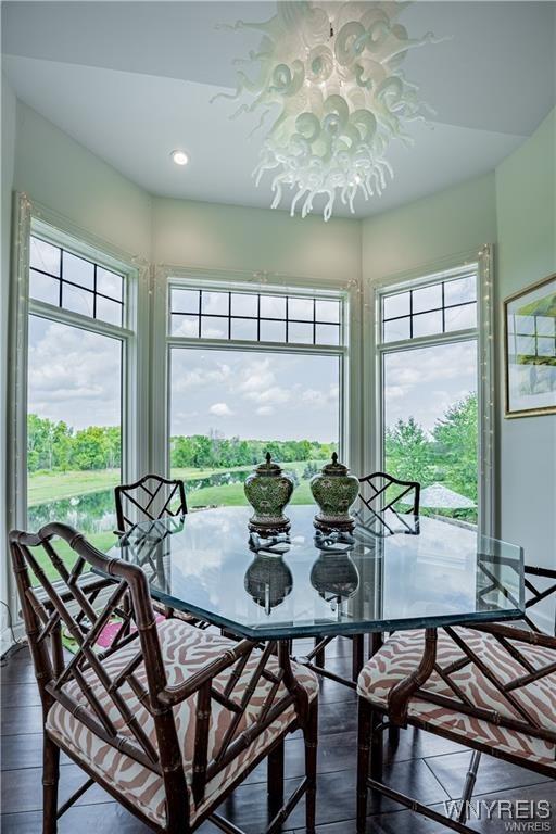 dining space featuring dark wood finished floors, recessed lighting, a wealth of natural light, and a notable chandelier
