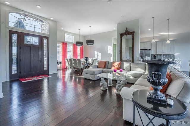 living area with recessed lighting, a high ceiling, and dark wood-type flooring