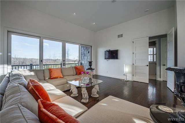 living room featuring dark wood-type flooring, baseboards, visible vents, and recessed lighting