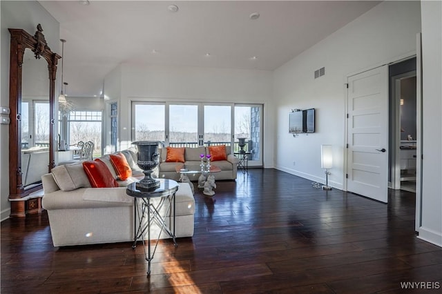 living room featuring visible vents, baseboards, and hardwood / wood-style flooring