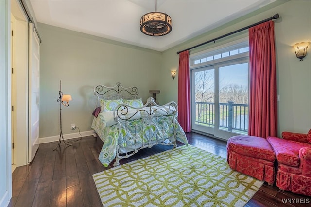 bedroom with wood-type flooring, baseboards, and access to exterior