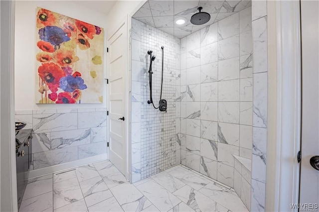 full bath featuring tile walls, marble finish floor, and tiled shower