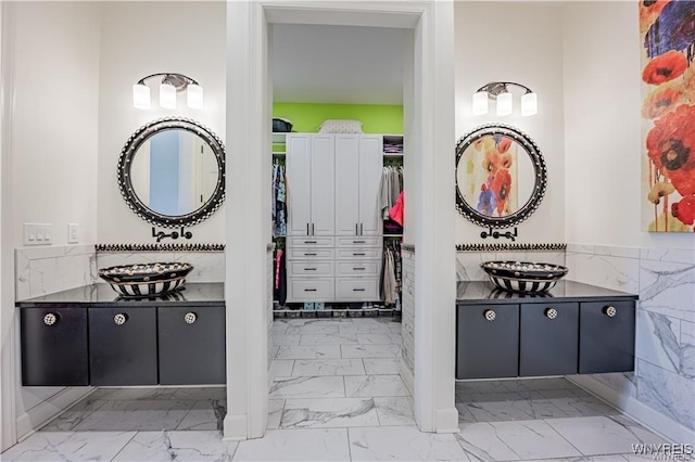 full bathroom with marble finish floor, vanity, and a spacious closet