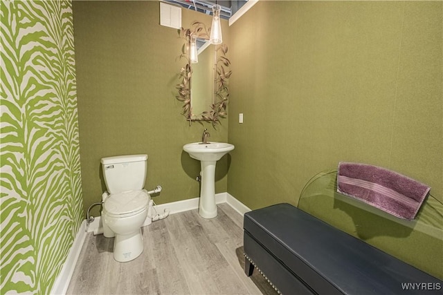 bathroom featuring toilet, baseboards, and wood finished floors