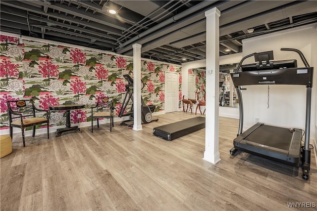 exercise room with baseboards and wood finished floors