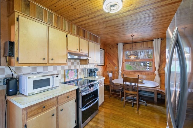kitchen with under cabinet range hood, light countertops, wooden ceiling, and stainless steel appliances