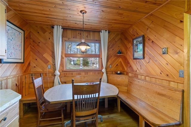 dining area featuring wooden ceiling, wood walls, and wood finished floors