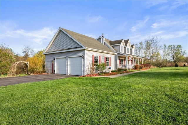 view of side of property with a porch, aphalt driveway, a garage, and a lawn