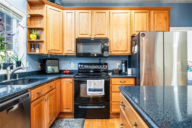 kitchen featuring a sink, dark stone countertops, open shelves, light wood-type flooring, and black appliances