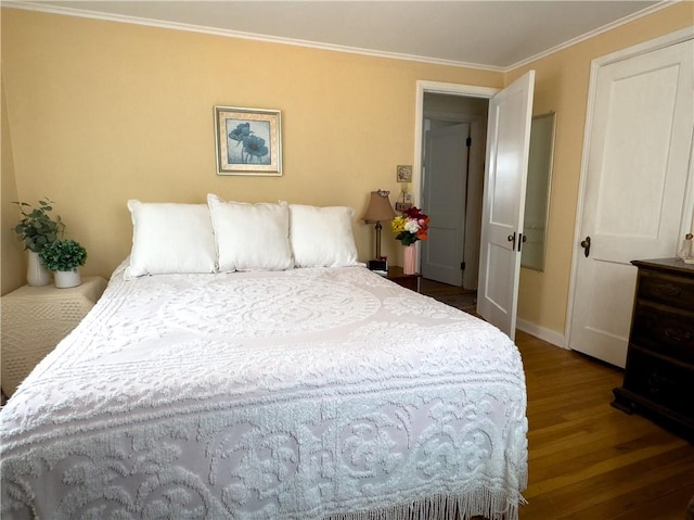 bedroom with baseboards, ornamental molding, and wood finished floors