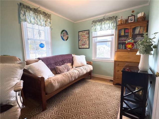 living area with plenty of natural light, wood finished floors, baseboards, and ornamental molding
