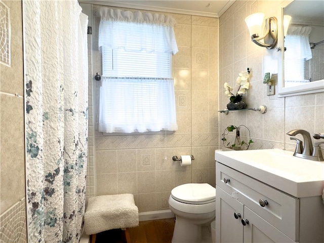 full bath with toilet, tile walls, and plenty of natural light