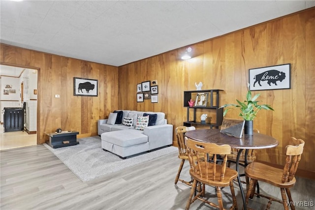 living area featuring wooden walls and wood finished floors
