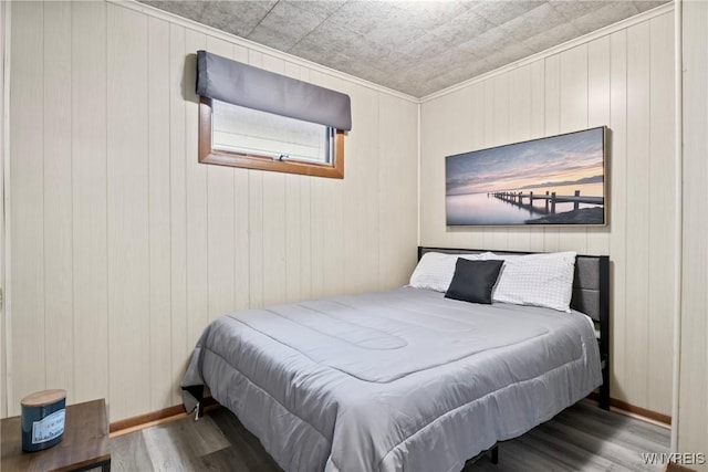 bedroom with baseboards and wood finished floors