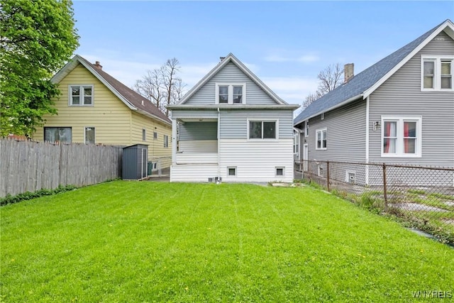 back of house featuring a fenced backyard, an outdoor structure, a storage unit, and a yard