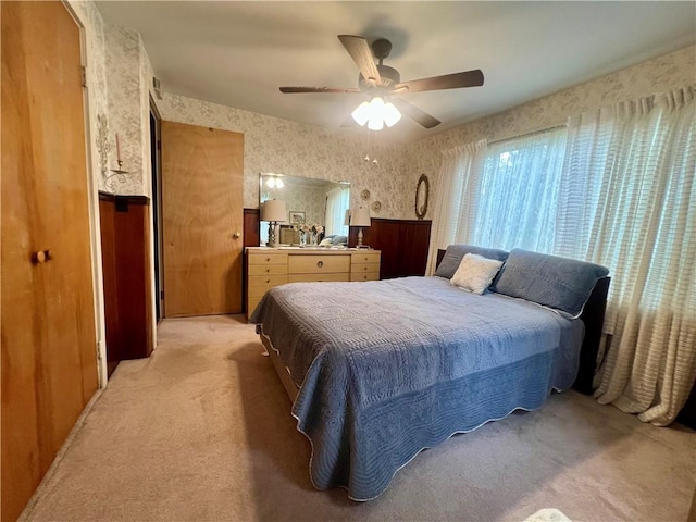 bedroom featuring light carpet, a ceiling fan, and wallpapered walls