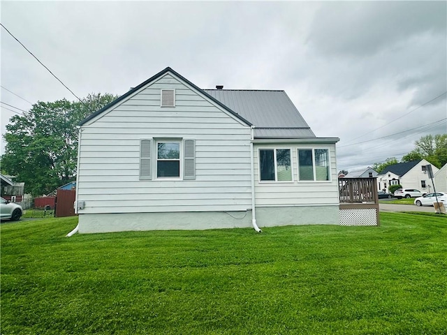 view of side of home featuring a yard and metal roof
