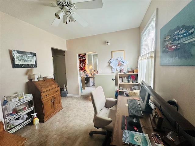 carpeted office with baseboards and a ceiling fan