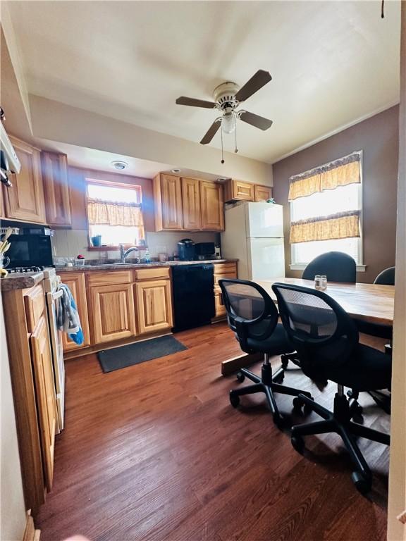 kitchen featuring white appliances, a sink, ceiling fan, and dark wood-style floors