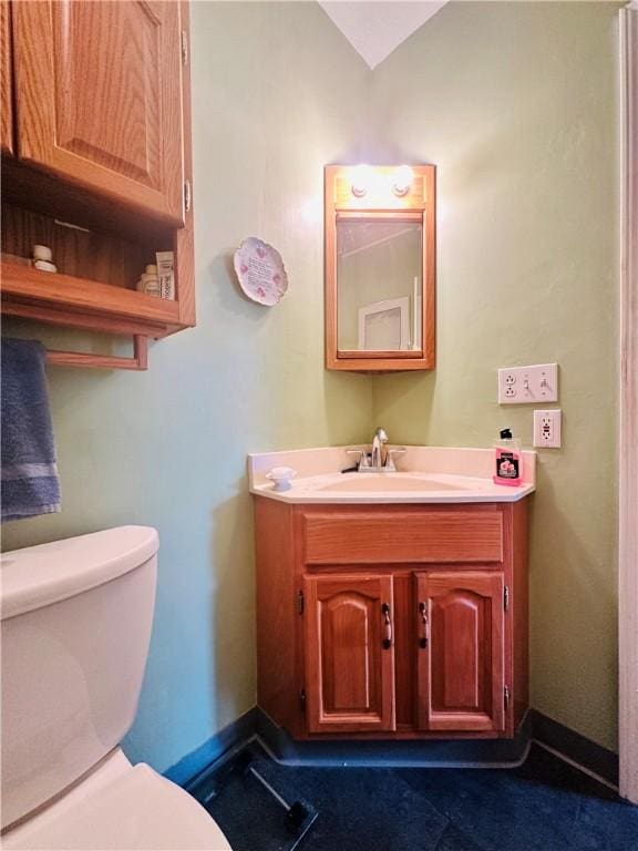 bathroom featuring vanity, toilet, and baseboards