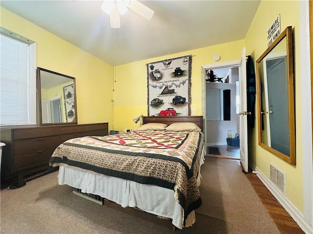 bedroom with baseboards, ceiling fan, visible vents, and wood finished floors